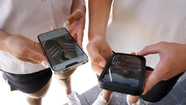 Two young teenagers use their phones to view social media