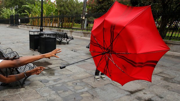A man in the French Quarter plays with his umbrella in the wind of Tropical Storm Barry in New Orleans, Louisiana.