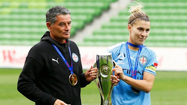 Steph Catley ve teknik direktör Rado Vidosic, A-League Kadınlar şampiyonluk kupasını taşırken.