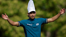 Min Woo Lee of Australia interacts with the crowd on the 17th party hole while wearing a chefs hat.