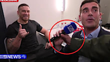 Sonny Bill Williams smiles as his agent Khoder Nasser rips the mic away from journalist Zac Bailey.