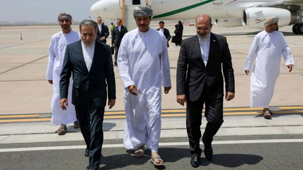 In this photo released by the Iranian Foreign Ministry, Iranian Foreign Minister Abbas Araghchi, left, is welcomed by an unidentified Omani official, center, upon his arrival at Muscat, Oman, for negotiations with U.S. Mideast envoy Steve Witkoff, as Iranian Ambassador to Oman Mousa Farhang walks at right, May 11, 2025.