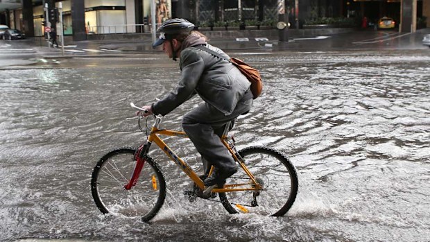 A cyclist rides through floodwaters in Southbank. (AAP)