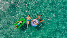 Photo of happy family relaxing in a sea water on inflatable swimming rings