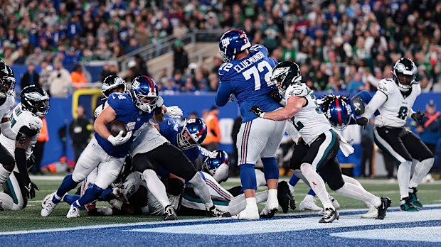 New York Giants oyuncusu Cam Skattebo topu taşıyor.