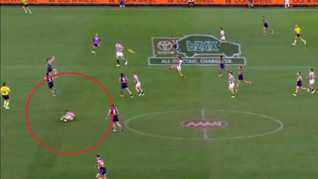 Play continues as Collingwood player Lachie Schultz lies on the ground.
