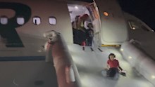 Passengers evacuate a airplane after a person was struck and killed by a Frontier Airlines plane during takeoff, at Denver International Airport.
