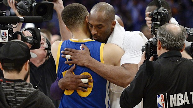 Kobe Bryant (R) embraces Steph Curry after their clash. (Getty)