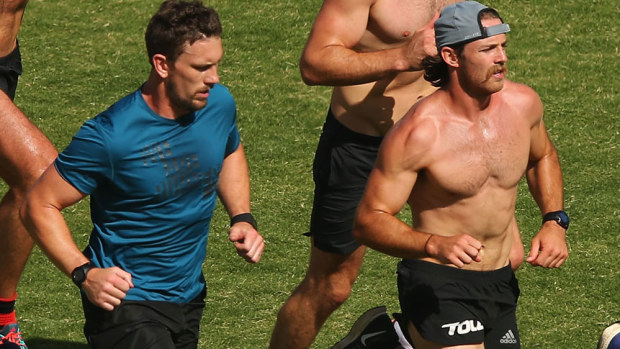 Heath Hocking (L) and Travis Colyer training with other banned Bombers players. (Getty)