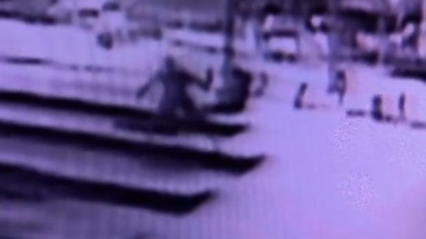 Security footage shows a man throwing rocks at the Lindt cafe in Martin Place.