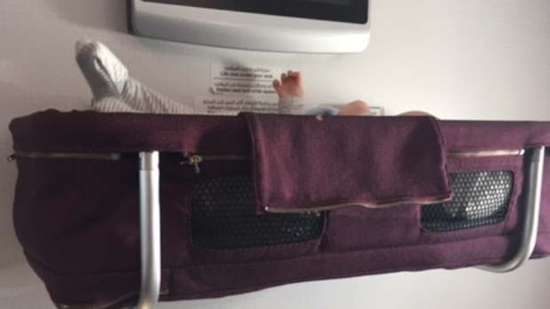 Baby in bassinet on flight.