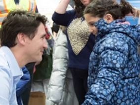 Canadian Prime Minister Justin Trudeau greets a Syrian refugee girl.