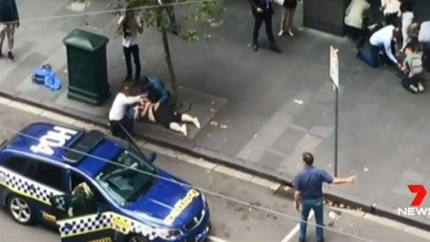 An image of Henry Dow and taxi driver Lou caring for a victim of the Bourke Street attack.