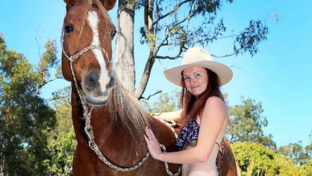 Kasey Dietz, wearing nothing but a bikini while walking her horse along roads, is raising awareness for horse safety.