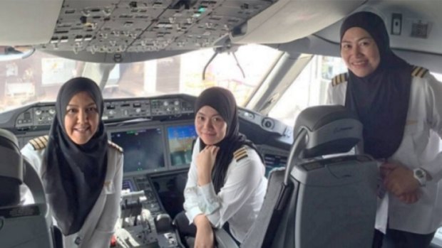 Royal Brunei Airline's first all-female flight crew, sitting in the cabin of a Boeing 787 Dreamliner.
