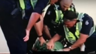 Officers restraining the 12-year-old boy on Friday.
