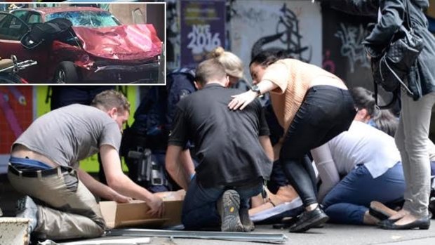People help the injured after a car ploughed through pedestrians in Bourke Street.