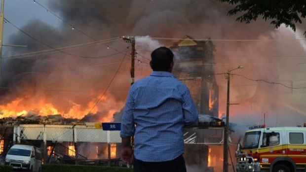 An onlooker watches on as the Royal Hotel, Roma burns.