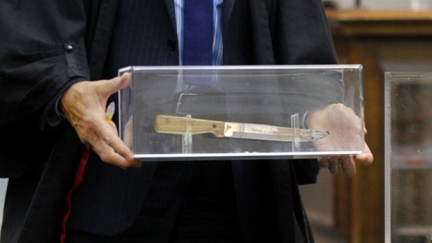 A court official displays the knife used to kill Mei Fan.