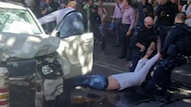 A man is dragged from a car in Flinders Street after an attack that left more than a dozen people injured