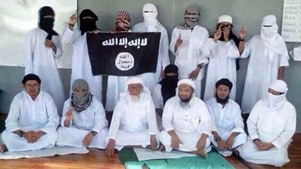 Radicalising influence: former Jemaah Islamiah spiritual leader Abu Bakar Bashir, front row centre, is photographed with the Islamic State flag inside Nusakambangan prison.  