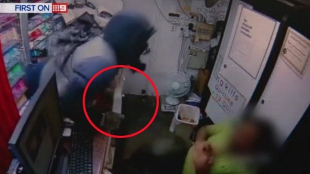 CCTV footage showing a Chippendale convenience store worker being attacked by a robber holding a knife (circled).