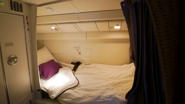 Flight attendants sleep in the area above economy class that has eight single beds with sheets, blankets and pillows.