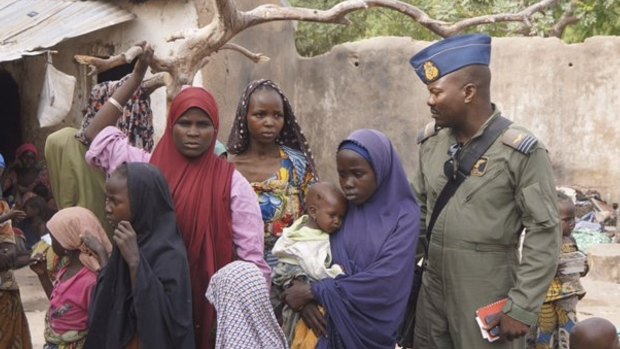 A soldier from the Nigerian Army talks with women and children who were freed from Boko Haram, in Yola.