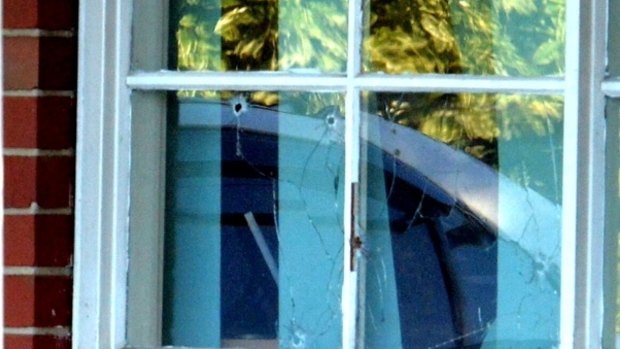 Bullet holes through the window of Darebin Drive house in Thomastown, where a man was murdered and child seriously injured.