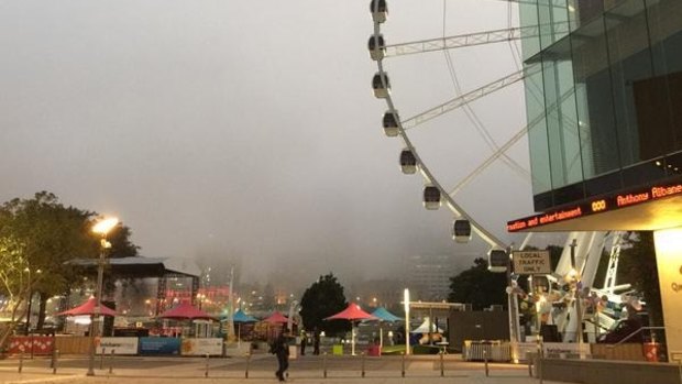 Fog covers Brisbane CBD, blocking the view from South Bank early on Friday.