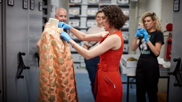 Charlotte Walker, Objects Conservator at Museums Victoria, with a piece from the Museum's archive.