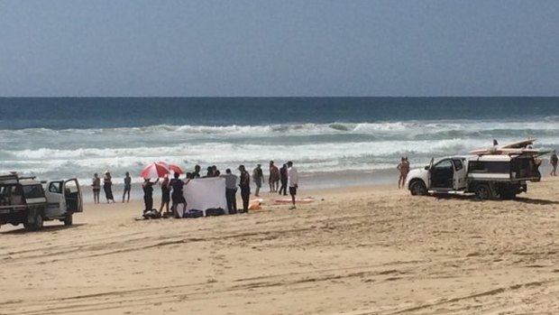 Paramedics and lifeguards worked unsuccessfully for more than an hour to revive a man pulled unconscious from the surf at Broadbeach.