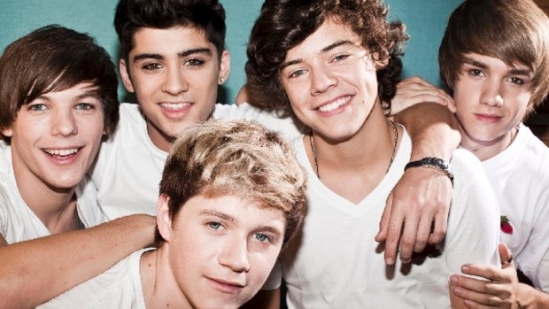 Fresh-faced One Direction in happier times: at left Louis and Zayn embrace in a band photo.