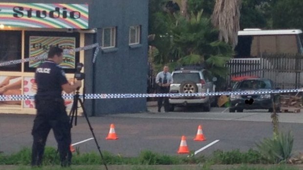 Police investigate a carpark in Booval where a woman was crushed to death by a car.