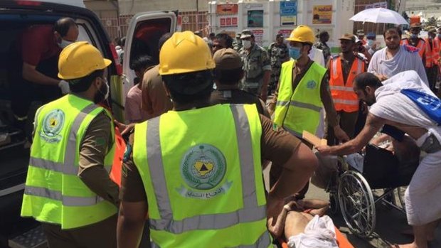 Emergency workers carry patients to waiting ambulances.