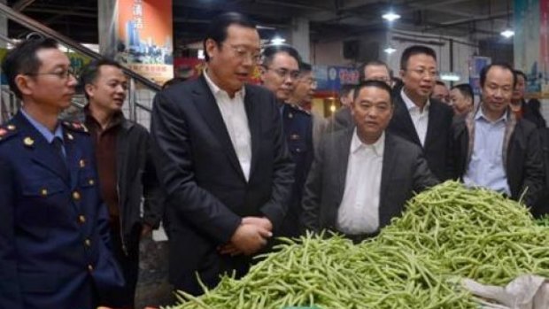 Panzhihua mayor Li Jianqin (third from left) and colleagues including gunman Chen Zhongshu (second from right) at a market just before Chinese new year.