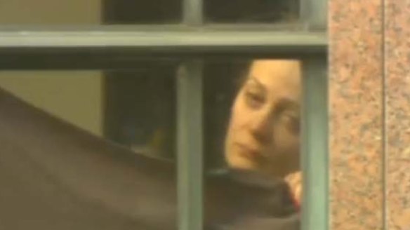 "Such upsetting footage": A hostage in the window of the Lindt cafe now identified as Marcia Mikhael who suffered a gunshot wound to the leg.