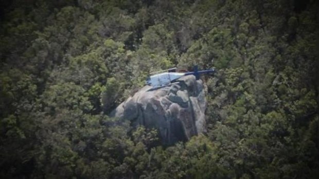A helicopter lies in a precarious position after crashing at Mount Cook, near Cooktown.