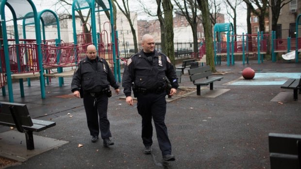 Police officers on Sunday cross Osborn Playground in the Brownsville section of Brooklyn, where an 18-year-old woman was raped by five young men.