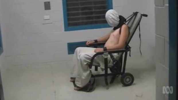 A teenage Dylan Voller has a hood placed over his head and is strapped to a chair at the Don Dale Detention Centre.
