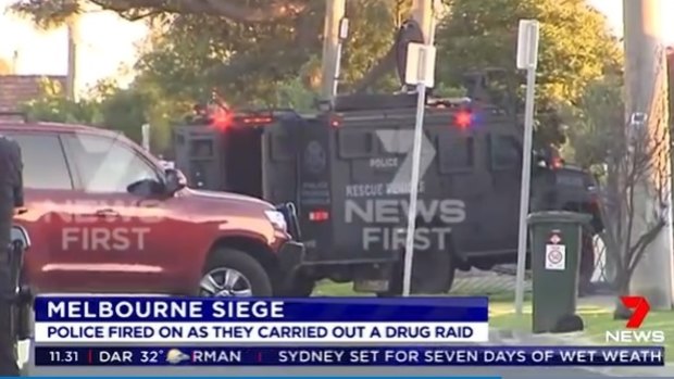 A heavily armoured vehicle tears down the fence at the St Albans property. 
