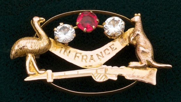 Nine carat gold sweetheart brooch with a boomerang engraved 'In France' and with emu, kangaroo and rifle set with one red and two white stones, c. 1915, by Alfred Jackson, Fremantle, $1500.

