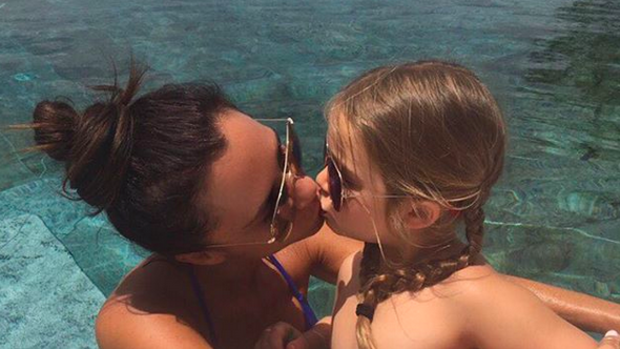 Victoria Beckham's lip-kiss to her daughter Harper has divided parents.