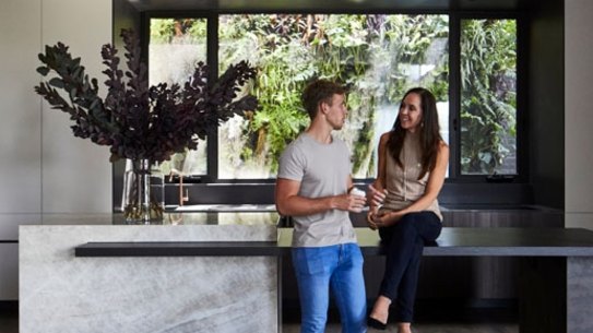 Janine and Riley in the kitchen. “The bench is made of virtually indestructible Dekton from Cosentino – Penny and I tested it with a jackhammer,” she says. 