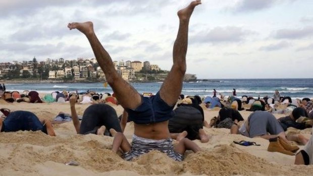 Australians bury their heads in the sands of Bondi Beach to send a message to Prime Minister Tony Abbott about the dangers of climate change.  