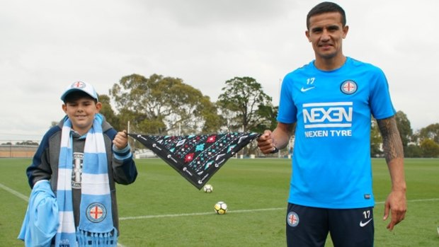Banding together: Tim Cahill, a young Melbourne City supporter and the CanTeen bandannas for sale.