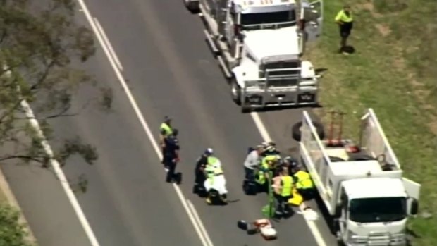 Emergency crews attend the scene of an incident on the Cunningham Highway where a man was hit by a truck while  changing a tyre.