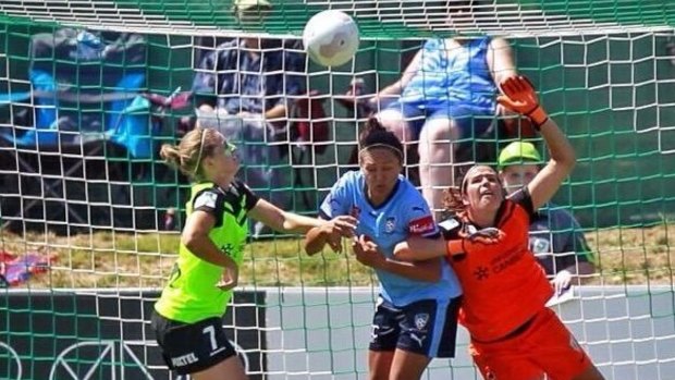 Canberra United goalkeeper Lydia Williams is obstructed by Sydney FC striker Kyah Simon.
