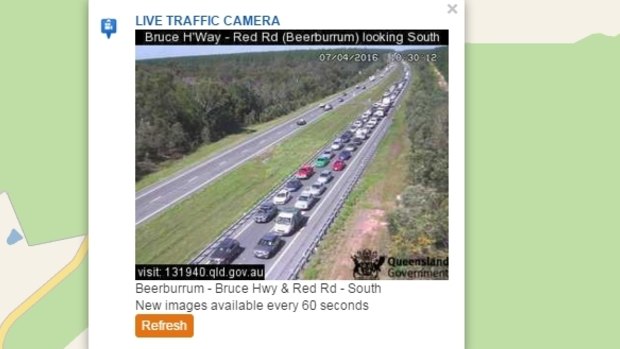 A car on fire on the Bruce Highway at Glasshouse Mountains is causing long delays. This traffic camera is at Red Road, about three kilometres south of the fire.