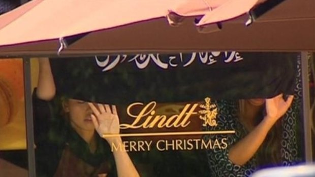 Hostages were seen holding an Islamic flag that is not the Islamic State flag against the window of the Lindt Chocolat Cafe in Martin Place.